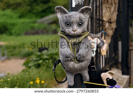 Handmade backpack in the shape of a cat made using wool felting technique. Eco friendly natural wool artisan craft accessory with playful and creative design.