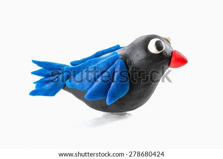 Handmade black bird with blue wings and red beak made out of play dough, play clay
