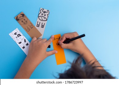 handmade bookmarks with bull or cow on blue background, paper craft for kids, hands draw, top view