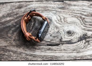 Handmade brown leather vintage smart watch strap craftsmanship on wood background