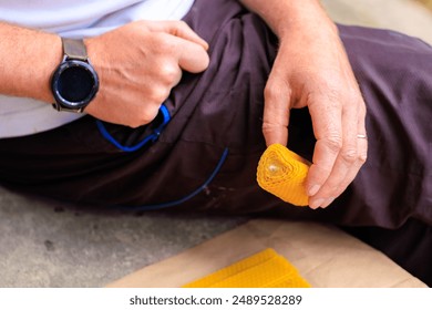 Handmade candle made of natural beeswax in the shape of a heart in the hands of a man. - Powered by Shutterstock