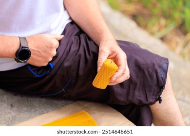 Handmade candle made of natural beeswax in the shape of a heart in the hands of a man. - Powered by Shutterstock