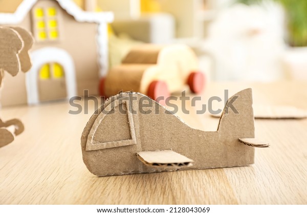 Handmade cardboard plane\
on wooden table