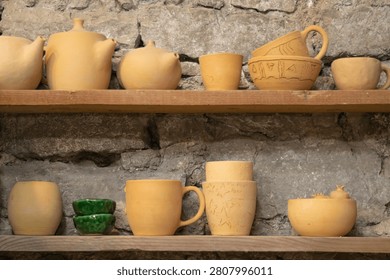 Handmade Ceramic Cups Drying on Shelves Before Kiln Firing in Pottery Workshop