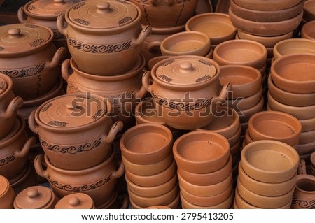 Hand-made ceramic items such as plates and pots are displayed on the counter.