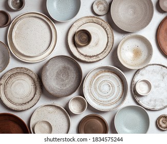 handmade ceramics, empty craft ceramic plates and bowls on light background, top view - Shutterstock ID 1834575244