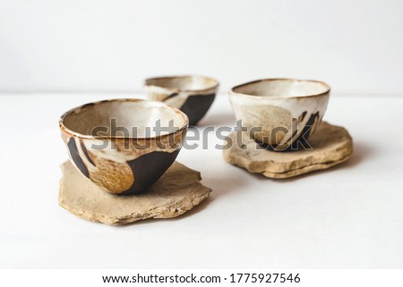 Handmade ceramics in the style of wabi sabi. Brown clay bowls with an abstract pattern.