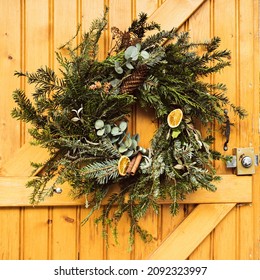 Handmade Christmas wreath made of evergreen tree branches dry fruits oranges pine cones - Powered by Shutterstock