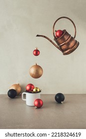 Handmade copper ewer jug pouring Christmas baubles into white metal cup. Holiday greeting concept. - Shutterstock ID 2218324619
