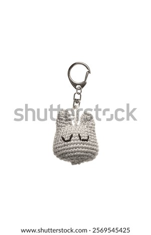 Handmade crochet keychain, featuring a cute gray cat face with closed eyes, attached to a metal keyring, perfect for adding a touch of charm to your keys or bag.