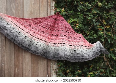 Handmade crochet shawl on wooden door - multicolored yarn.
