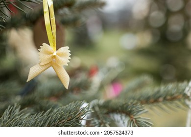 Handmade Decoration Made Of Farfalle Pasta And Penne Pasta On A Christmas Tree. Diy Ideas. Environment, Holiday Cooking And Italian Recipes Concept. Selective Focus, No Snow Outdoor Background