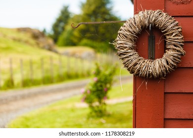 Handmade decorative objects concept. Rounded wicker decoration hanging on wooden wall