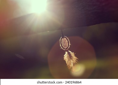Handmade dream catcher hanging on a wooden fence in sunset of a beautiful sunny day