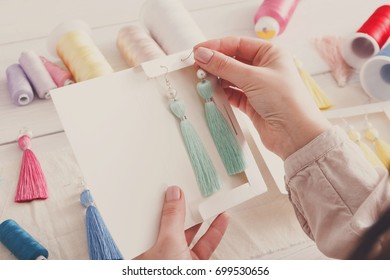 Handmade earrings packing, home workshop. Woman artisan put tassel jewelryinto original boxes, top view. Art, hobby, handicraft concept - Powered by Shutterstock