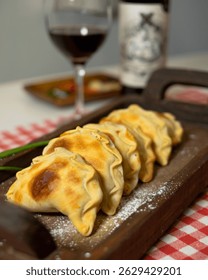 Handmade empanadas on rustic surface, showcasing golden texture and homemade filling. Food product photography with a culinary focus.