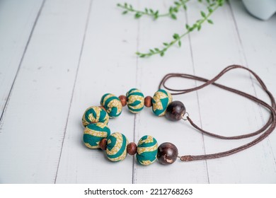 Handmade Fabric Necklace With Coconut Shell Beads On White Wooden Table. Etnic Handmade Jewelery.