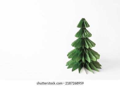 Handmade foldable Christmas tree from plastic free material - green paper isolated on white background. DIY concept.