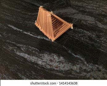 Handmade Fruit Basket On Bross Blue Granite Countertop.  Abstract Image Of A Boat In Ocean Wave.