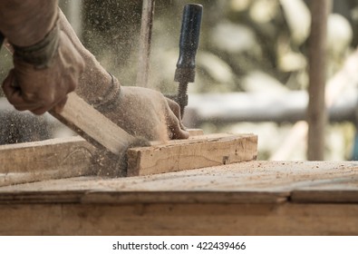 Handmade furniture workshop concept: Carpenter engaged in processing wood at the sawmill