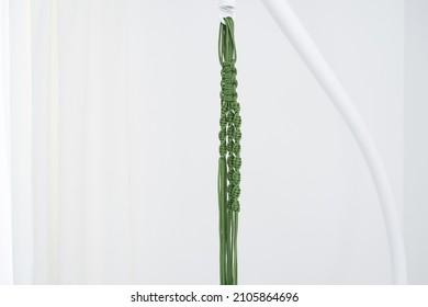 Handmade Green Macrame Plant Hangers With Potted Plant Are Hanging On Woman Hand. Pot And Monstera Plant