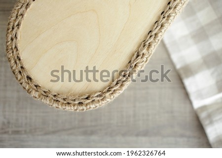Handmade home decor made from organic jute fiber and wood. wooden oval bottom of a jute basket on the table.