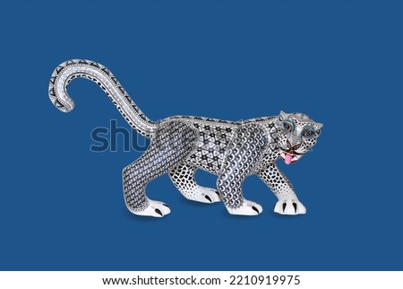 Handmade jaguar sculpture made of wood and hand painted by an ethnic group from Mexico. White jaguar isolated on a blue background.
Alebrije, typical and traditional sculpture from Oaxaca, Mexico.