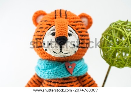 Handmade knitted soft toy. Amigurumi. Tiger toy with mice on the white background. Crochet stuffed animals. Portreit. Knitting and crocheting