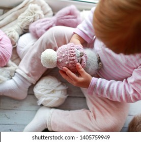 Handmade knitted toy. Amigurumi penguin toy in baby's hands. Crochet stuffed animals. Top view. Concentration and emotional intelligence. Learn through play. Playing process.
