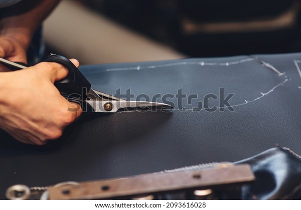 Handmade leather craftsman. Worker sewing\
leather product. Leather worker workshop. Working process of sewing\
car seat cover. Man holding crafting tool and working, close up.\
Making things\
handmade.