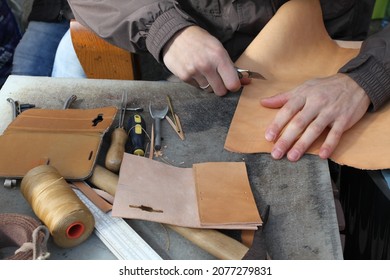 Handmade leather goods, craftsman at work in a workshop.