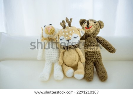 handmade mascots on a white background. Yarn teddy bears.
Soft toys for a baby. Natural, handmade toys for a child. Knitted masks. Crochet masks. Teddy bear, lamb and deer - hand sewn