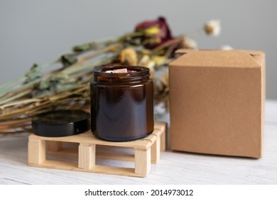 Handmade organic soy candle on a neutral background. Square kraft box for candle packaging and shipping. Amber and opaque packaging. Vegan product without animal cruelty. - Shutterstock ID 2014973012