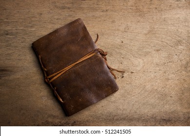 Handmade Paper Diary Notebook In Brown Leather Cover With Orange Bookmark Over Old Vintage Wooden Table Surface Background