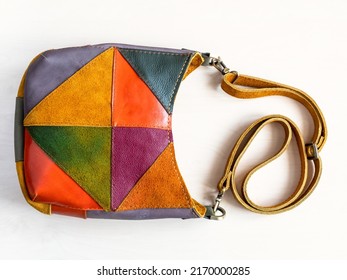 handmade patchwork crossbody bag hand sewn from suede and leather on white background