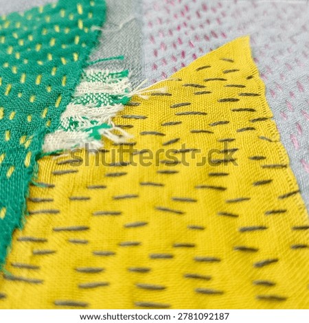 Handmade patchwork embroidery with visible stitches. Close up handmade textile compositions combining patchwork fabric layers and sashiko inspired stitching. Textured embroidery details photographed as contemporary craft backgrounds and textile studies.