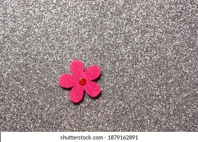 A Handmade Pink Flower Lapel Pin On A Shiny Background