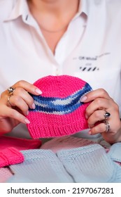 Handmade Pink Knitted Baby Hat. Knitted Products In Hands, Knitting From Yarn With Knitting Needles Is Not Just A Hobby, A Useful Activity