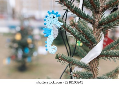 Handmade Plastic Seahorse Decoration On Christmas Tree Outdoors. Diy Ideas For Children. Environment, Recycle, Reuse, Upcycling And Zero Waste Concept. Selective Focus, No Snow Background