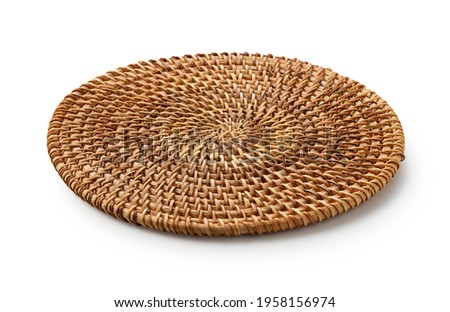Handmade round woven placemat placed on a white background.
