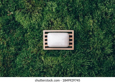 Handmade Shampoo, Soap Bar On Wooden Dish Over Green Moss Texture. Copy Space. Top View. Zero Waste, Eco Friendly Product, Natural Organic Bathroom Tool. Ecological Skin Care, Body Treatment Concept.