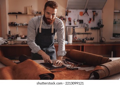 Handmade shoe, man tailor or cobbler measuring and cutting brown leather on workplace. - Powered by Shutterstock