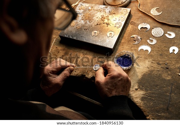 Hand-made\
silver items with cloisonné enamel in progress. Traditional work in\
the mountain village of Kubachi,\
Dagestan.