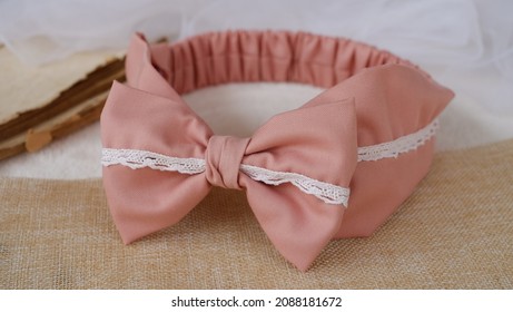 Handmade simple headband made out of cotton fabric with bow pattern in soft peach color, great as hair accessories for girls and women.