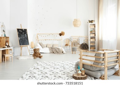 Handmade Sofa On Carpet In Spacious Girl's Room With Plush Toy Next To Chalkboard