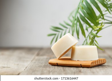 Handmade solid shampoo soap bar on wooden dish. Green leaves above and copy space for text. Zero waste, eco friendly product - Shutterstock ID 1713616447