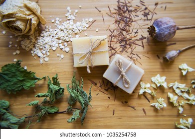 Handmade spa soap bars with natural ingredients. Organic soap making, skin care. Dried  herbs, oats, rose blossoms on wooden vintage background. Spa treatments.