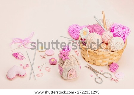 Handmade spring decor concept. Creative crocheting, house figurine, traditional flowers and hearts. Festive greeting card, gentle pastel apricot background, copy space