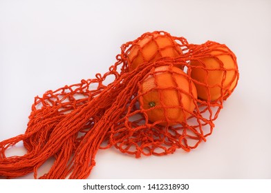 Handmade string bag with three oranges