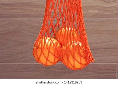 Handmade string bag with three oranges